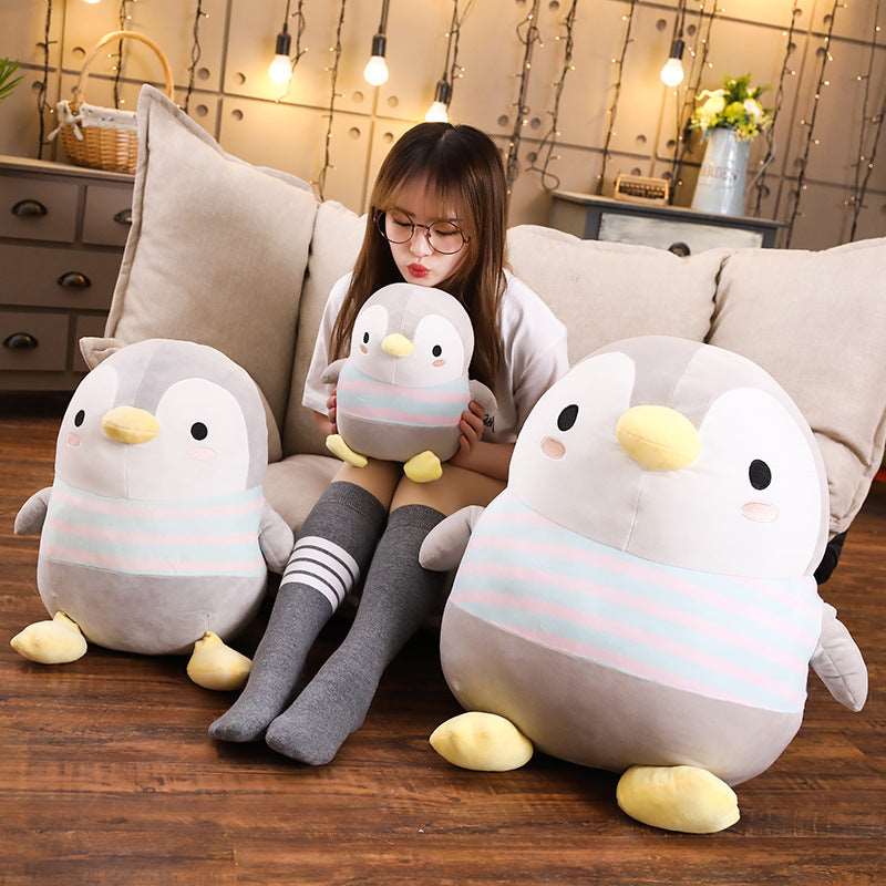 Drei Pinguin Plüschtiere auf der Couch mit Mädchen