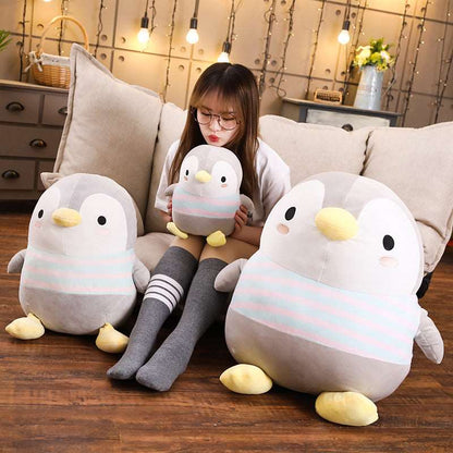 Drei Pinguin Plüschtiere auf der Couch mit Mädchen